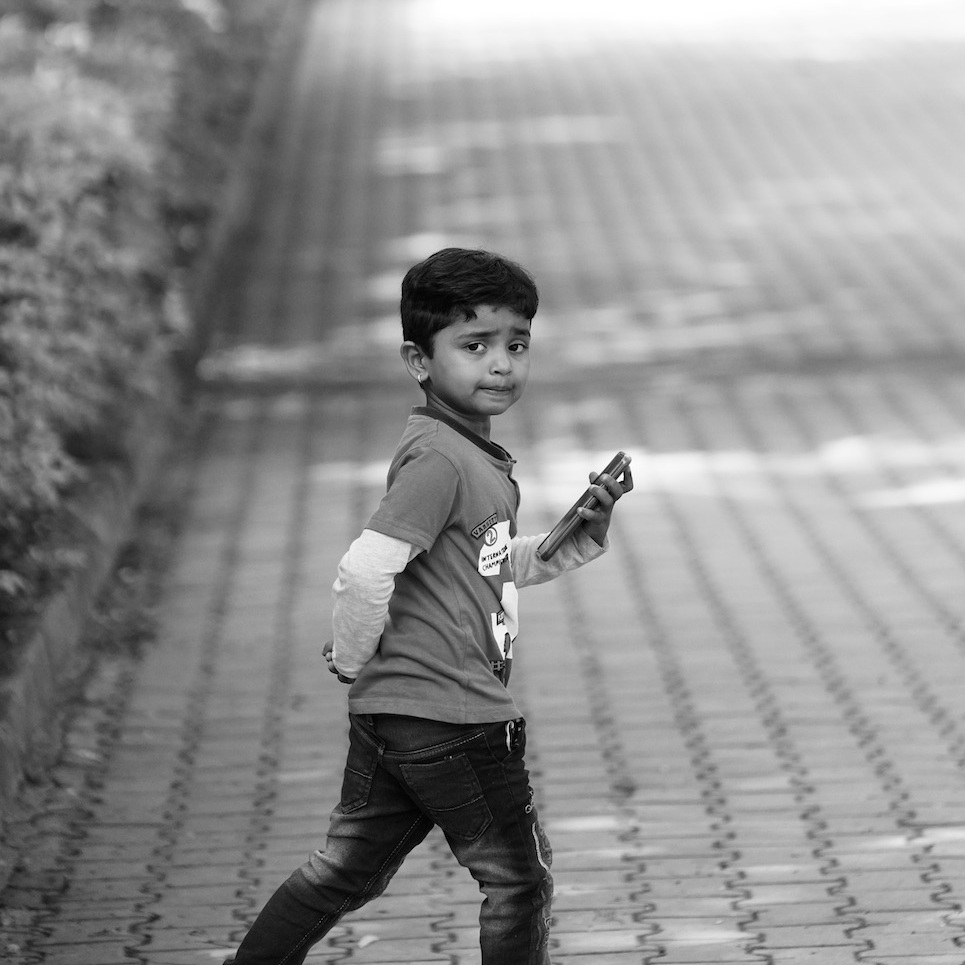 Unhappy Child with phone. Shot in Bangalore, Karnataka, India.